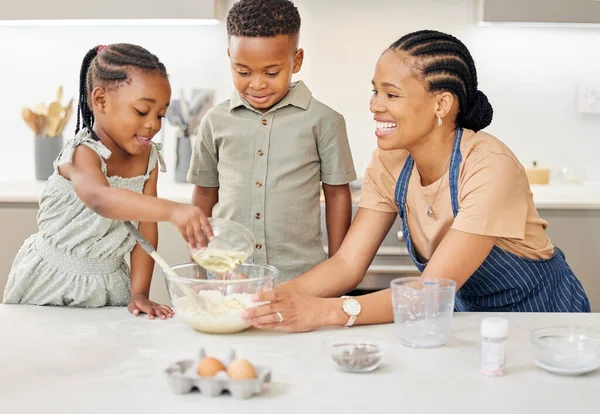 We all share a love of food. an attractive young mother bonding with her children while helping them bake in the kitchen at home