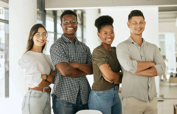 Portrait of successful creative business team looking at camera and smiling. Diverse business people standing together with their arms crossed at startup.