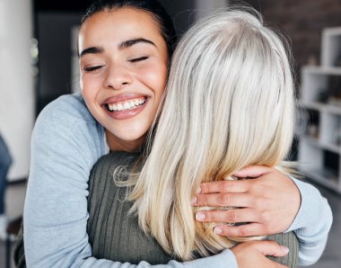 Love, comfort and woman hugging her mother for support, peace or consoling in their family home. Happy, smile and young lady embracing her mature mom with care, happiness and affection at their house.