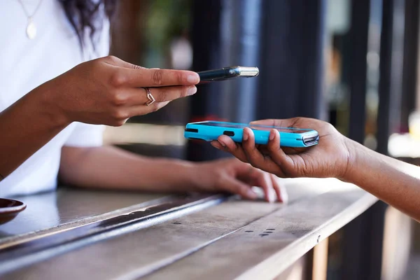 Woman, hands and phone for ecommerce, scanning or transaction on wireless card machine at coffee shop. Hand of customer scan or tap to pay, buy or banking app with smartphone or 5G connection at cafe.