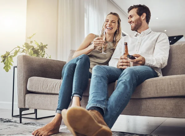 Love, couple on sofa and alcohol to relax, smile and bonding on weekend break, loving and romantic. Romance, man and woman with beer, champagne and celebrate achievement, happiness and in living room.