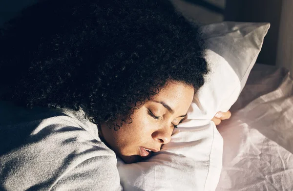 Sleep, black woman and bed in morning for peace, quiet and rest or relax in home bedroom. Person face on pillow to dream or for calm sleeping with insomnia or fatigue therapy for health and wellness.