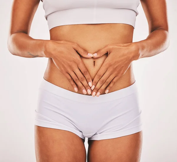 Gut health, hands in heart and stomach of woman on white background for digestion, diet and weight loss. Fitness, body wellness and abdomen of girl for healthy lifestyle, tummy tuck and liposuction.