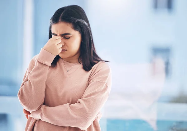 Headache, stress or anxiety with an indian woman on a blurred background suffering from pain or burnout. Compliance, mental health or mistake and a frustrated young female struggling with a migraine.