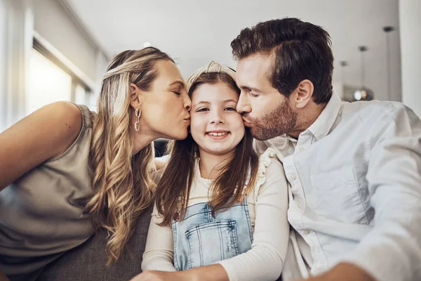 Portrait, mother or father kiss a girl or child as a happy family in living room bonding in Australia with love or care. Relax, trust or parents smile with kid enjoying quality time on a fun holiday.