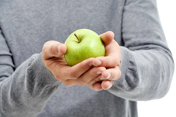 Hand, wellness and male in a studio with a apple for nutrition, diet and a healthy snack with vitamins. Health, natural and healthy man or person with fresh, organic and raw green fruit for a craving.
