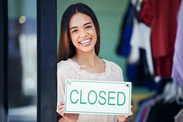 Business owner, holding and portrait of a woman with a sign for a closed shop in the afternoon. Smile, entrepreneur and retail employee showing a board for a store closure, advertising and news.