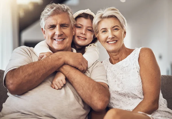 Portrait, happy family or grandparents hug a girl in living room bonding in Australia with love. Retirement, smile or elderly person relaxing with old woman and child at home together on fun holiday.