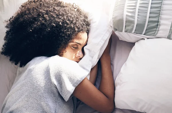 Sleeping, bedroom and relax with a black woman in bed, dreaming or resting in the morning at home. Sleep, tired and rest with an attractive young female asleep in her house over the weekend.