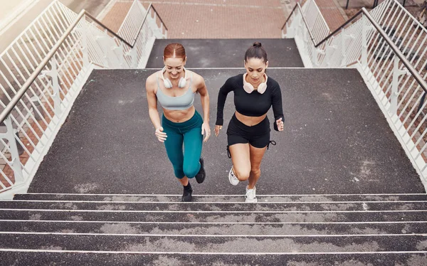 Fitness, sports or friends running on steps exercise together for healthy lifestyle, wellness or exercising for marathon. Athletes, runners or fast women training in cardio workout on stairs in city.