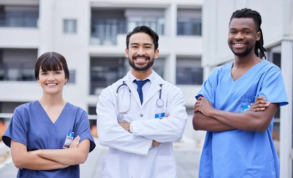 Portrait, healthcare or collaboration with a doctor and team standing arms crossed outside of a hospital. Medical, teamwork or trust with a man and woman professional medicine group feeling confident.