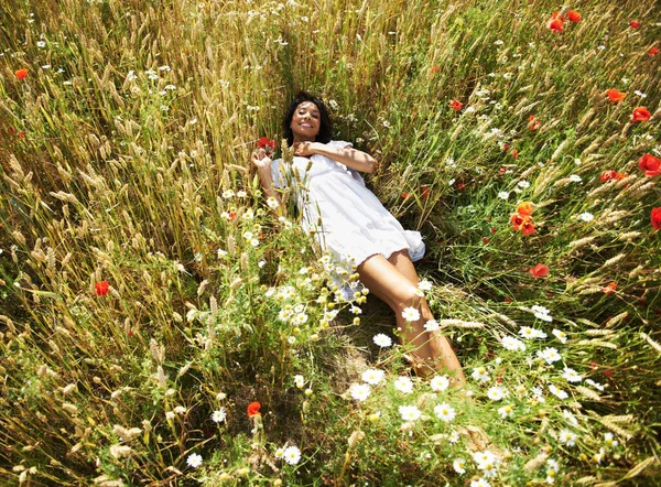 Taking it easy. Portrait of a pretty woman lying down in a field
