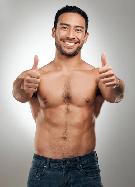 Youre on the right track to better health. a handsome young man standing shirtless in the studio and showing a thumbs up