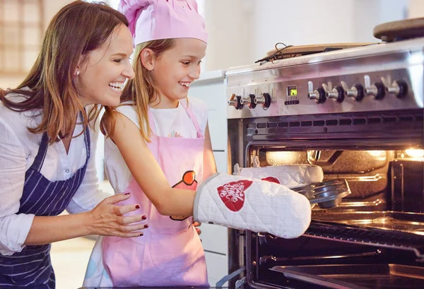 I think theyre done. an attractive young mother bonding with her daughter in the kitchen at home while baking