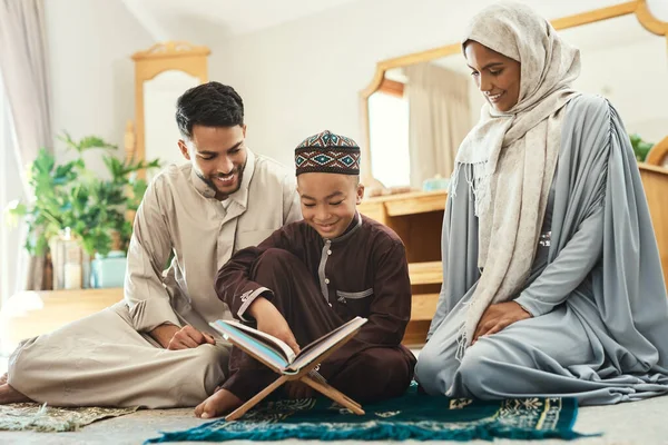 Books let you travel without moving your feet. a young muslim couple and their son reading in the lounge at home