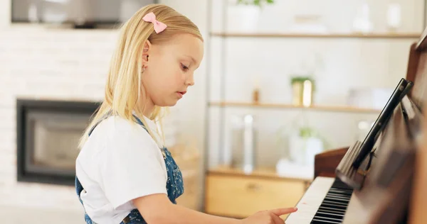 Development, young girl and piano for learning, practice and keys for instrument being focus, concentrate and educate. Music, tablet and child education for playing, lesson and training art at home