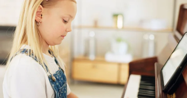 Development, young girl and piano for learning, practice and keys for instrument being focus, concentrate and educate. Music, tablet and child education for playing, lesson and training art at home