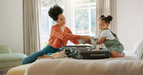 Travel, luggage and mom packing with child in bedroom getting ready for trip. Helping hands, black family and young girl help mother pack clothes in suitcase for holiday, vacation and weekend away.