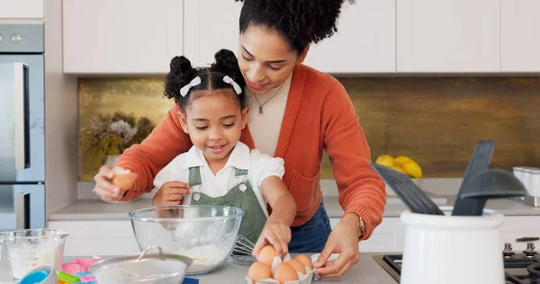 Mother, child and baking with eggs in the kitchen for family bonding, learning and fun with ingredients at home. Happy mom teaching helpful kid to bake, cook or mix for recipe together at the house.