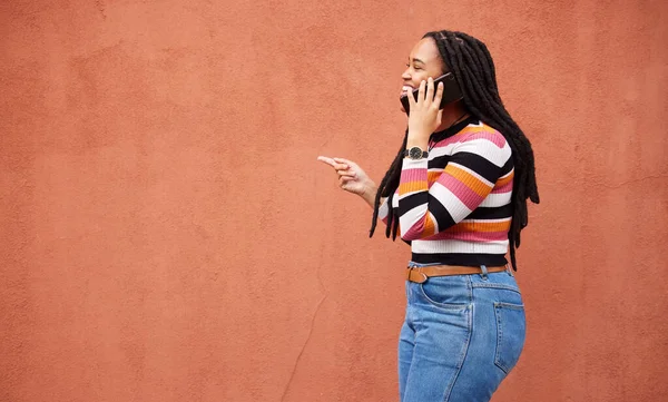 Happy black woman, phone call and smile on wall background with happiness, conversation and mockup space. African female talking on mobile, color mock up and smartphone communication with technology.
