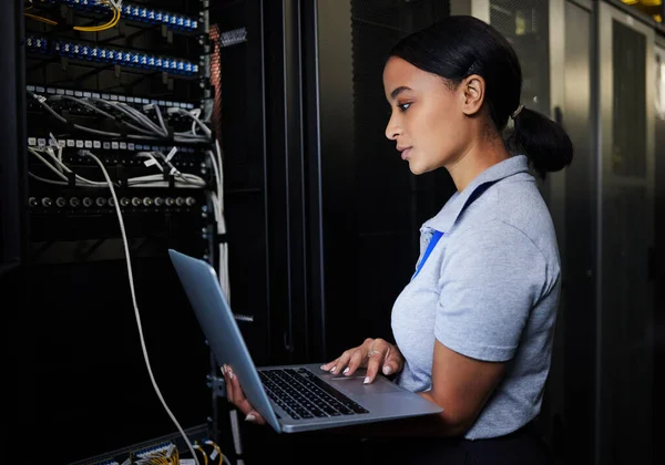 Engineer, laptop database and woman in server room for software update or maintenance at night. Cybersecurity coder, cloud computing and female programmer with computer for networking in data center