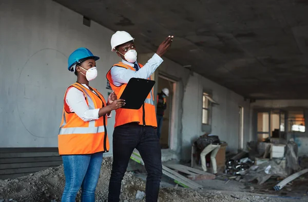 Teamwork keeps a construction project on track. a young man and woman having a discussion while working at a construction site