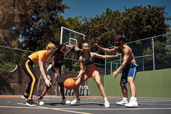 Playing basketball requires agility, strength and stamina. a group of sporty young people playing basketball on a sports court