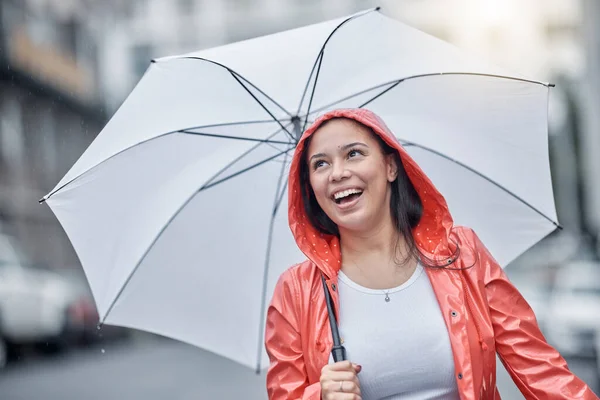 Outdoor, umbrella and black woman with smile, city and freedom on break, joyful and cheerful. Jamaican, female and lady with cover from rain, town and urban with happiness, comfortable and travel.