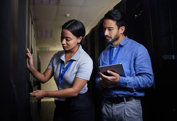 Engineer teamwork, server room and woman opening panel for maintenance or repairs at night. Cybersecurity, programmers and female with man holding tablet for software or networking at data center