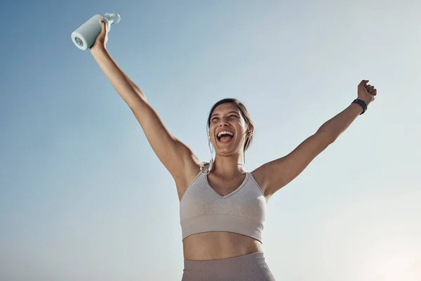 Fitness success, blue sky and woman arms in air with water bottle outdoor. Excited, happy smile and athlete with sports feeling freedom from motivation and happiness with exercise target goal.