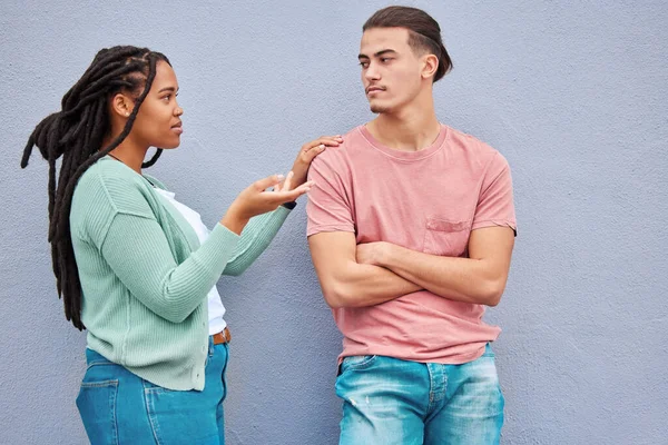 Young interracial couple, wall background and argument in city with black woman, question and conversation. Gen z man, partner and conflict in metro with relationship, fight and angry arms crossed.