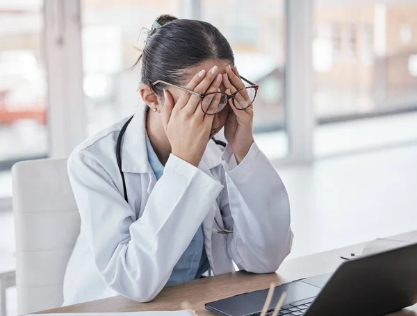 Burnout, stress or doctor woman on laptop with headache from depression, mental health or anxiety medical review. Tired, pain or sad nurse frustrated, angry or depressed for medicine report in office.