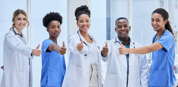 Portrait, team of doctors and thumbs up for teamwork, support and hospital services mission. Medical nurses, people or diversity employees face for healthcare like, vote and thank you emoji hands.