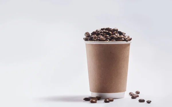 Life is too short for bad coffee. Studio shot of a paper cup filled with coffee beans against a grey background