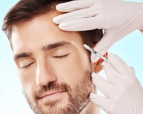Face, cosmetic injection and mesotherapy with man, hands and needle syringe, skincare and medical on blue background. Healthcare, beauty and healthy skin with procedure, cosmetics and dermatology.