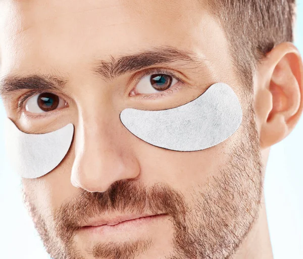 Eye beauty, man portrait and treatment patches for eyes in a isolated studio with white background. Skincare, spa wellness and facial for model face with cosmetics, dermatology and detox with mask.