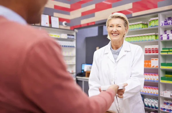 Service, medical and pharmacist with medicine for a man for healthcare product at a pharmacy. Smile, help and clinic woman giving a patient pills for an illness, flu or cold while working in health.