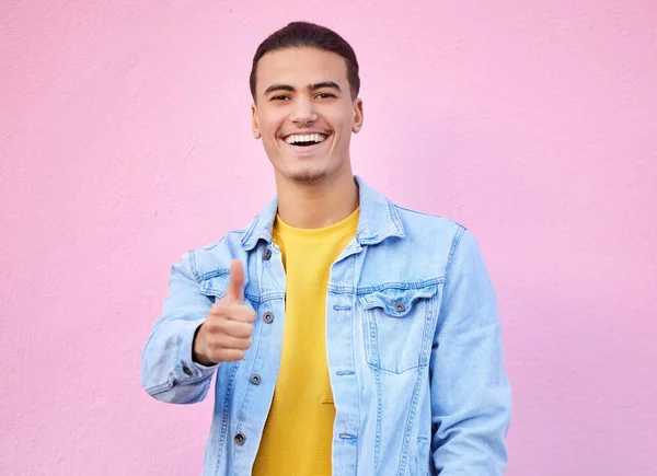 Thumbs up, motivation and portrait of a man with a thank you isolated on a pink background in studio. Success, win and person with a hand sign for support, trust and emoji icon for agreement.