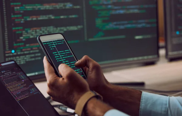 Phone in hands, code and man coding, programmer and software update with information technology and screen. Cybersecurity, ux and network with wifi, web design and cyber space with cpu programming.