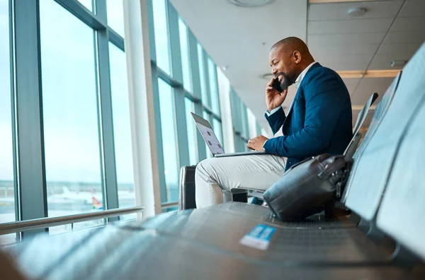 Phone call, travel and businessman on a laptop in the airport for work company trip in the city. Technology, communication and African male employee on mobile conversation waiting to board his flight.