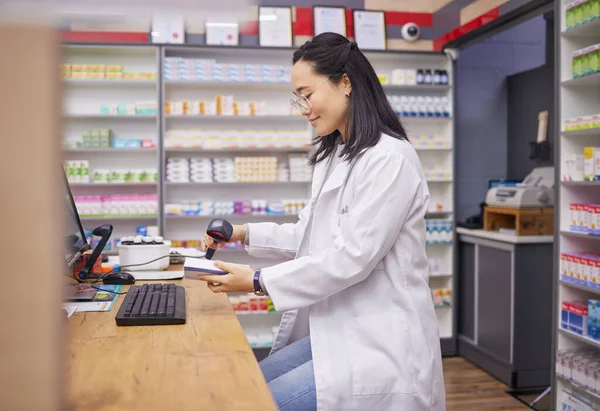Pharmacy, help and asian woman at checkout counter for prescription drugs scanning medicine. Healthcare, pills and pharmacist from Japan with medical product in box and digital scanner in drugstore