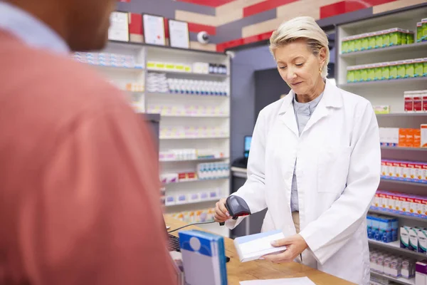 stock image Pharmacy, barcode scan and senior woman pharmacist with customer buying medicine and pills. Store payment, pharmaceutical clinic and healthcare worker scanning code for patient payment in shop.