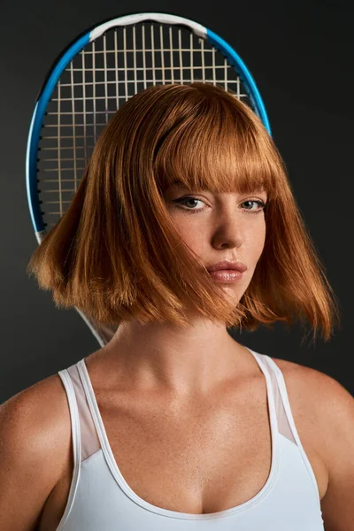 If you feel good then you play good. a young woman posing with a tennis racket against a dark background
