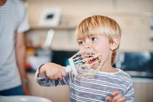 If you didnt lick the batter did you even bake. an adorable little boy licking the batter from a whisk while baking at home