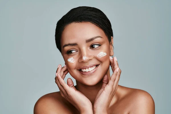 Moisturize and youll feel the difference. a beautiful young woman applying moisturizer to her face