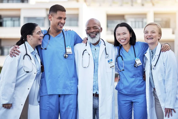 Healthcare, collaboration and doctors with nurses in medicine standing outdoor at a hospital as a team you can trust. Medical, teamwork or laughing with a man and woman medicine professional group.