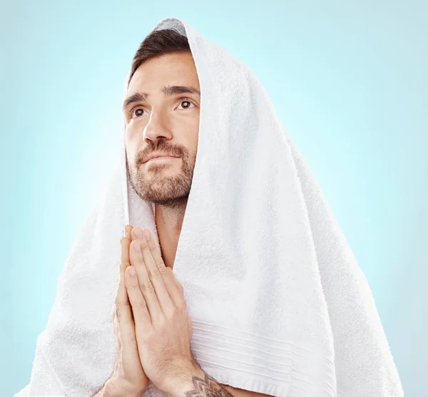 Prayer, thinking and worship with man and towel for hope, spiritual and Catholic faith. Respect, religion and Holy spirit with guy and hands for believer, humble and Christianity with blue background.