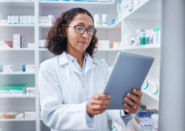 Senior woman, tablet and pharmacist in pharmacy for healthcare or stock check online in drugstore. Medication, telehealth technology and female medical doctor with touchscreen for research in shop