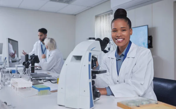 Black woman, microscope and portrait of scientist in laboratory for research, experiment or innovation. Science, technology and happy female medical doctor with equipment for sample analysis or test.