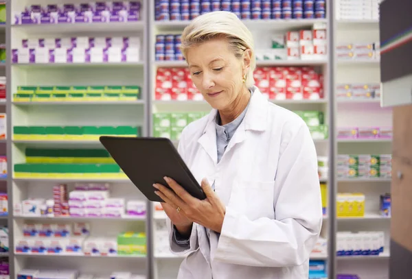 Pharmacy, tablet and pharmacist woman for product management, stock research and inventory data app. Digital technology, retail logistics and senior healthcare doctor or person with medicine software.